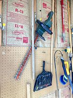 Full view of hedge trimmer hanging on pegboard wall