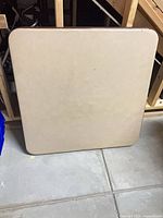 Front view of square beige-brown card table