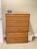 Front view of five-drawer oak-finish chest