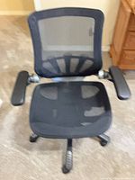 Front view of black mesh office chair showing seat, backrest, armrests and caster base