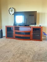 Front view of cherry wood entertainment cabinet under television