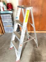 Werner 4-ft aluminum folding ladder standing open showing three steps and rubber feet