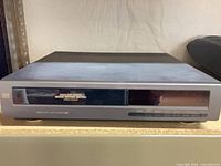 Front view of grey VCR showing slot, display window and control buttons