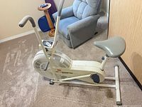 Left side view of DP Air Gometer bike showing frame, fan housing, seat, pedals, and moving handlebars