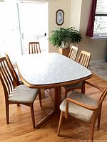 Table with protective pad and six chairs positioned around it
