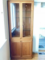 Full view of teak wood hutch showing glass upper section and wooden lower cabinet