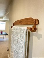 Front view of wall-mounted wooden quilt rack holding a quilt