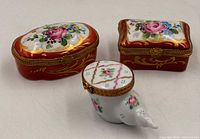 Group of three hinged porcelain trinket boxes showing overall designs