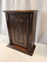 Front view of carved cabinet closed