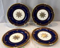 Four cobalt blue Aynsley service plates displayed on stands