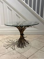 Side view of coffee table showing gilt metal wheat base and glass top