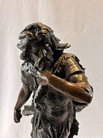 Close view upper torso head and sling detail bronze statue