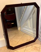 Front view of octagonal mirror showing wood frame and glass surface