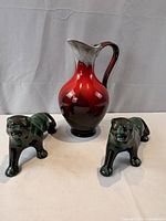 Front view of red flambé pitcher and two green drip-glaze cats