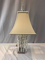 Full view of crystal table lamp with shade and finial
