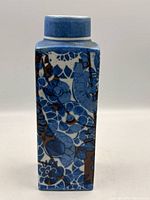 Front view showing blue and brown floral pattern on square body