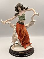 front view of figurine showing pose, colors, signature on base