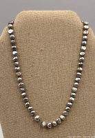 Full view of necklace on display bust showing shape, length, color