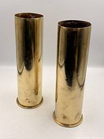 Two upright brass shell casings showing full exterior