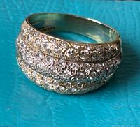 Angled view showing three diamond rows and two-tone gold