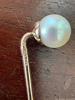 Close-up of pearl end and 14K hallmark on shaft
