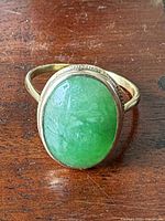 Top view of gold ring showing oval green jade stone