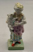Front view of Meissen porcelain figurine showing girl with kitten