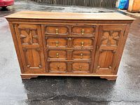 Front view of walnut dresser showing drawers, doors, bracket feet