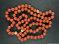 Full view of coiled red coral necklace showing three gold spacer beads