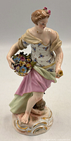 Front view of Porcelain Spring figurine showing woman, basket, colours