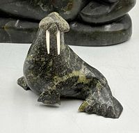 Front view of stone walrus sculpture with tusks visible