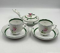 Full lot view showing two cups on saucers and lidded sauce boat