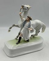 Front view of porcelain figurine showing trainer and rearing horse on base