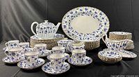 Full set front view showing platter, plates, bowls, teapot, cups, gravy, cream, sugar, nut dishes