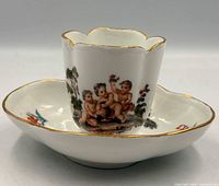 cup on saucer showing overall shape, painting and gilt trim