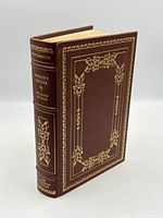 Front and spine of leather-bound book showing gilt decoration and raised bands