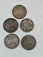 Obverse or reverse views of five 19th-century silver coins laid out for identification