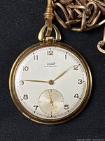 Front view of Tissot pocket watch showing dial and part of chain