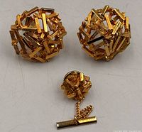 Front view of cufflinks and tie pin showing textured gold-tone design