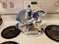 Front view of porcelain Alexander Nevsky figurine on stove