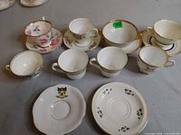 Group shot of assorted teacups and saucers laid out on tabletop