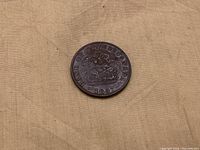 Obverse of 1857 Bank of Upper Canada half penny token on cloth background