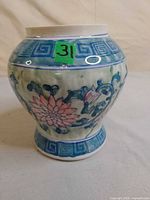 Front view of porcelain vase showing floral design and Greek key border