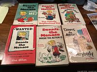 All six Dennis the Menace paperback comics laid out showing front covers and titles
