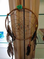 Full view of dreamcatcher showing hoop, web, hanging feathers
