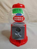 Front view of the red Dubble Bubble gumball dispenser showing globe, logo and coin mechanism