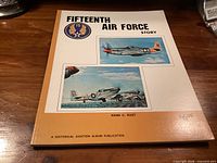 Front cover of Fifteenth Air Force Story book showing title, author, publisher emblem, aircraft illustrations
