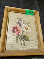 Framed needlepoint showing floral bouquet; full view of frame and stitched design