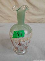 Front view of clear glass vase with frosted green neck, hand-painted red and gold floral design, flared rim