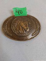 Front view of oval belt buckle with horse head motif